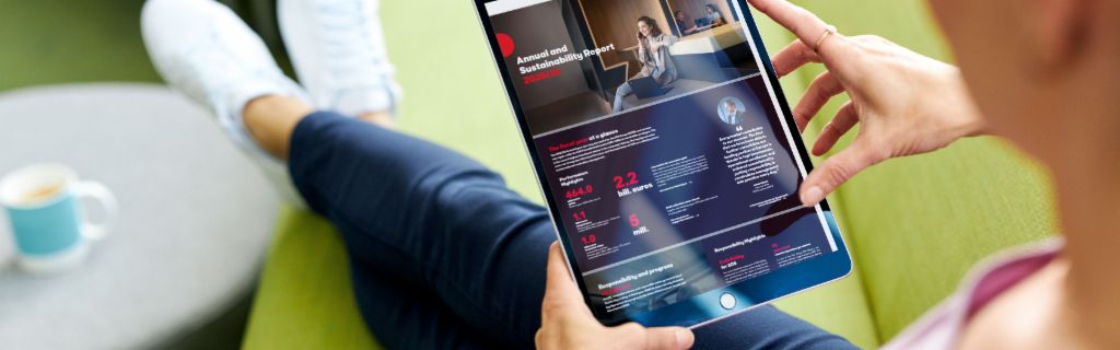 EOS ASR: Zdjęcie przedstawia młodą kobietę trzymającą tablet i przeglądającą na nim Roczny Raport Zrównoważonego Rozwoju EOS.