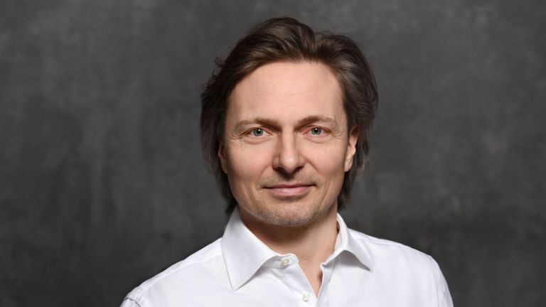 Ekspert ds. cyberbezpieczeństwa Janusch Skubatz, dyrektor ds. bezpieczeństwa informacji w Grupie EOS, w brązowych włosach i białej koszuli.