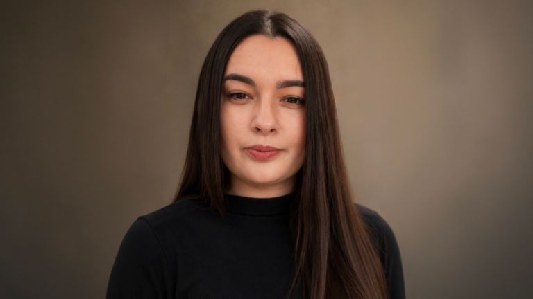 Daniela Moaca, Senior Manager IT w EOS Romania, zdjęcie portretowe w ciemnym golfie.