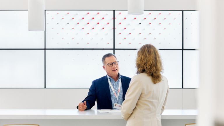 EOS employee talking with client in EOS lobby