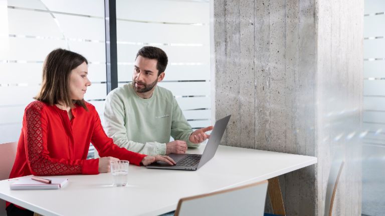 Two EOS colleagues with laptop in meeting room