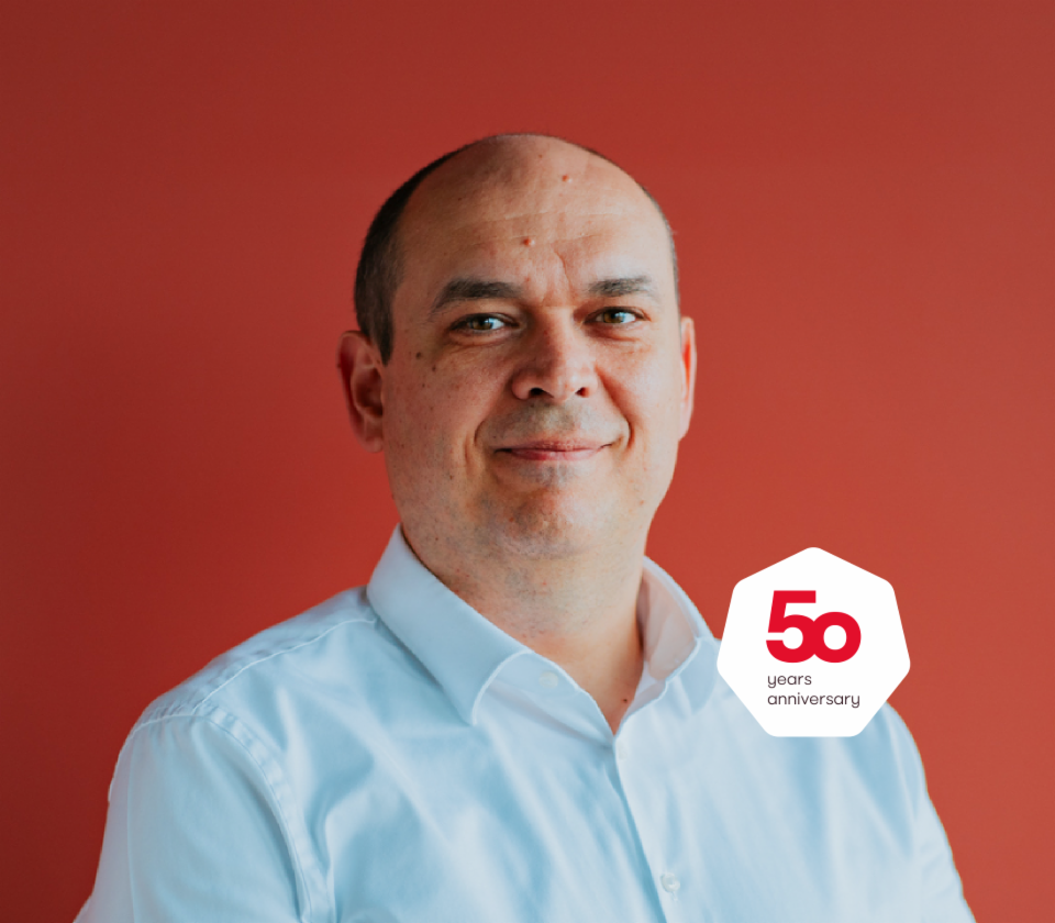 Zdjęcie portretowe Cristiana Musata, Managing Director w EOS Technology Solutions, na czerwonym tle