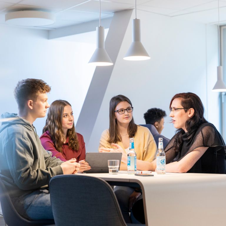 A group of young EOS trainess working together in a modern break room
