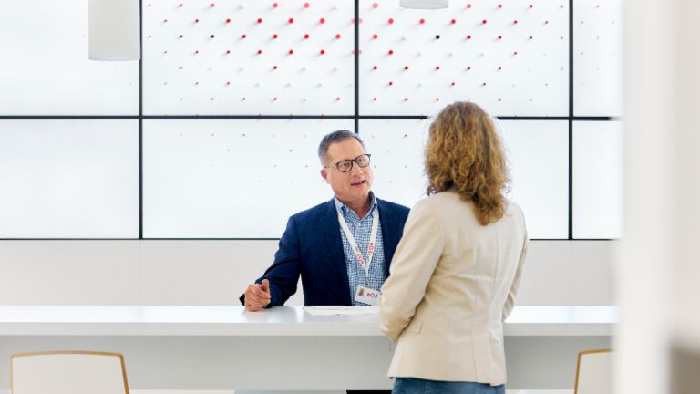 EOS employee talking with client in EOS lobby