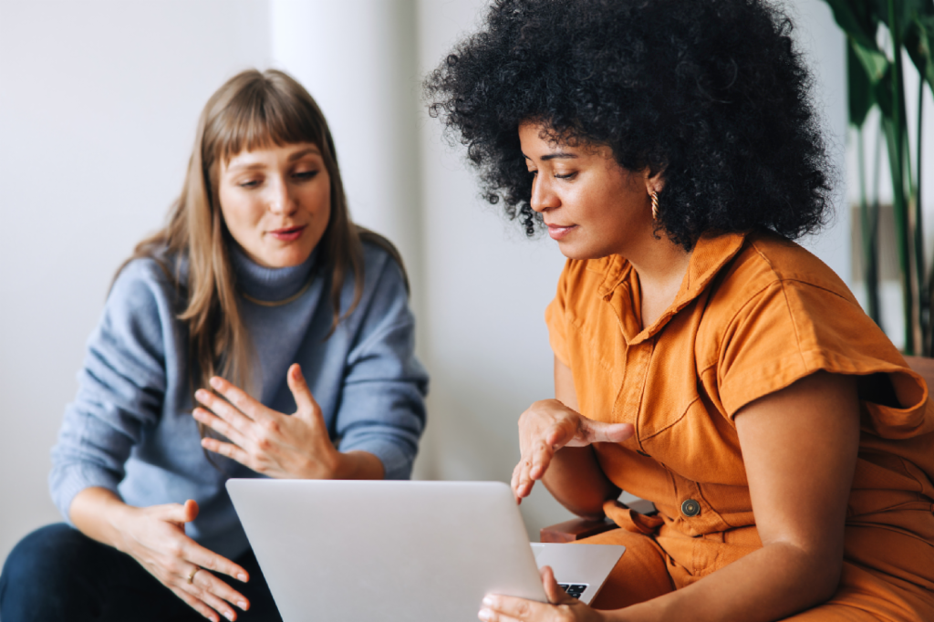 Young woman on her cell phone next to an EOS team member with headphones and two women talking