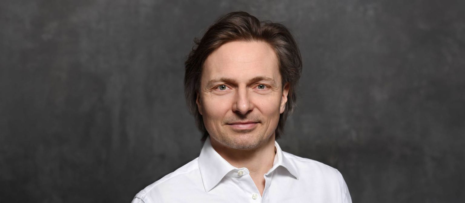 Ekspert ds. cyberbezpieczeństwa Janusch Skubatz, dyrektor ds. bezpieczeństwa informacji w Grupie EOS, w brązowych włosach i białej koszuli.
