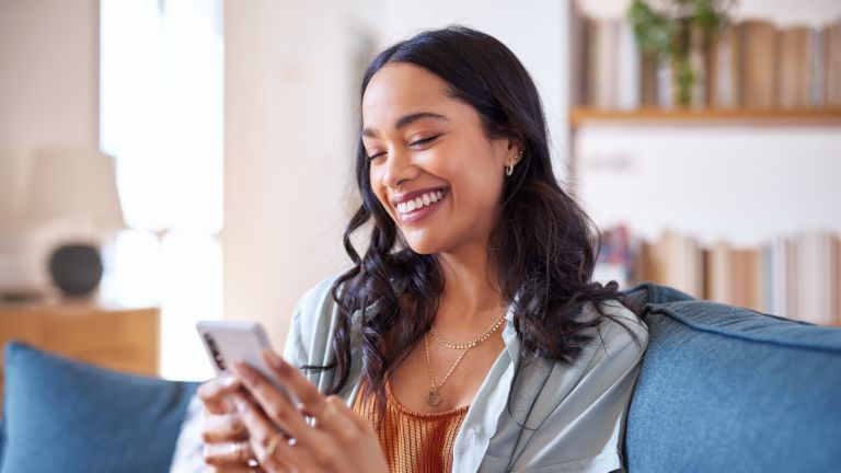 Woman sitting on a sofa and using smartphone